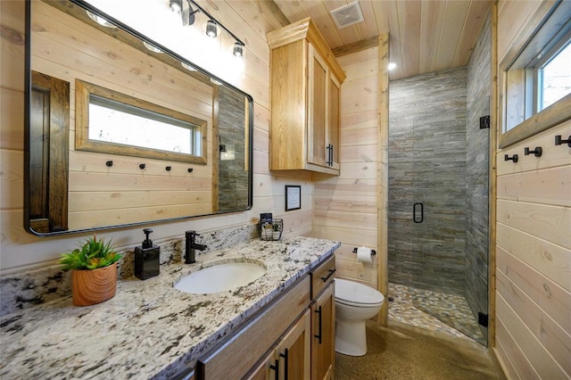 bathroom with plenty of natural light, wooden walls, vanity, and walk in shower