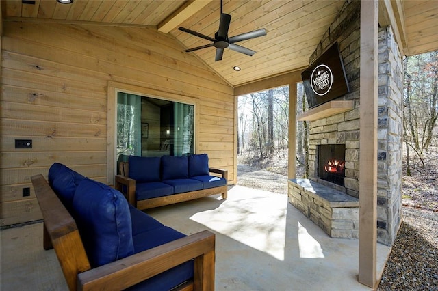 view of patio / terrace featuring ceiling fan and an outdoor living space with a fireplace