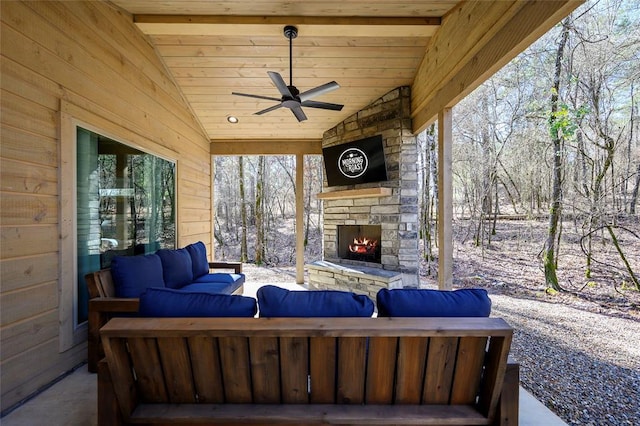 view of patio featuring ceiling fan and an outdoor living space with a fireplace