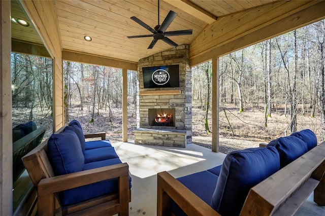 view of patio featuring ceiling fan and an outdoor living space with a fireplace