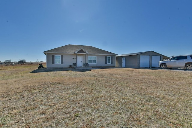 ranch-style house with a garage, an outbuilding, and a front yard