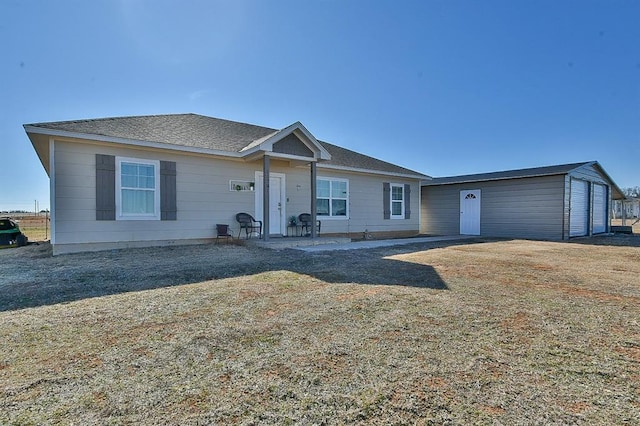 ranch-style home with a garage, a front yard, and an outdoor structure