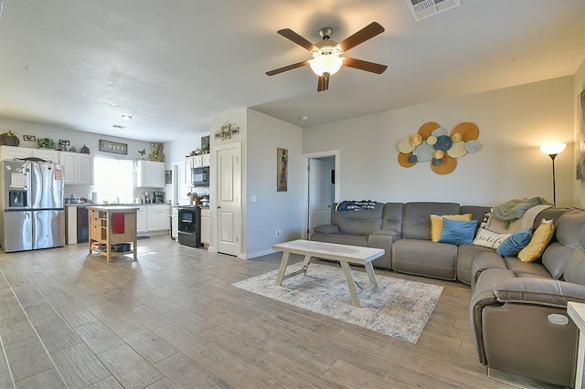 living room featuring sink and ceiling fan