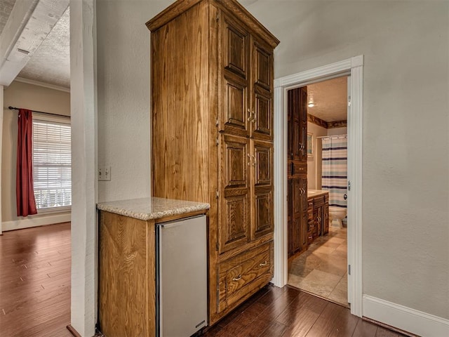 hall with crown molding, dark hardwood / wood-style floors, and a textured ceiling