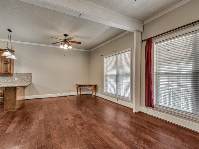 unfurnished living room with crown molding, plenty of natural light, dark wood-type flooring, and a textured ceiling