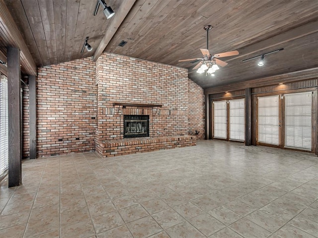 unfurnished living room featuring lofted ceiling with beams, brick wall, wood ceiling, and a brick fireplace