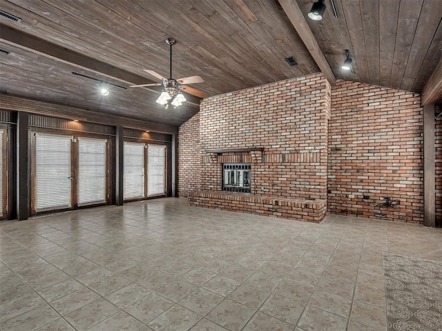 unfurnished living room with ceiling fan, lofted ceiling with beams, brick wall, a brick fireplace, and wooden ceiling