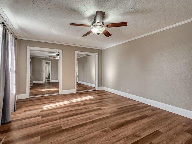 unfurnished bedroom with ornamental molding, wood-type flooring, and ceiling fan