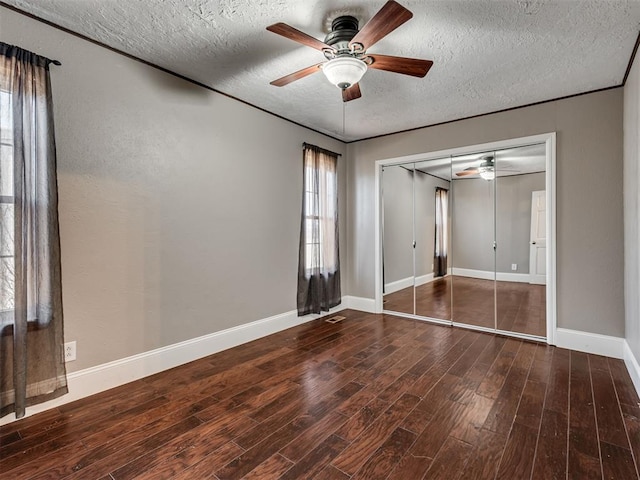 unfurnished bedroom featuring wood-type flooring, a textured ceiling, ceiling fan, and a closet