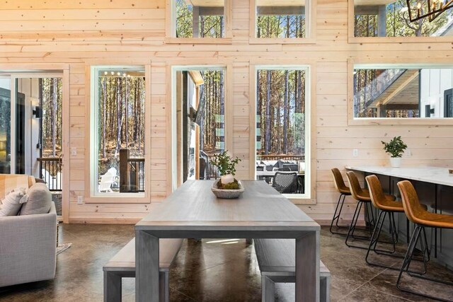 tiled dining room with a towering ceiling and wooden walls