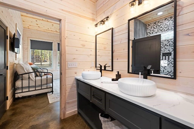 bathroom featuring concrete floors, wooden walls, and vanity