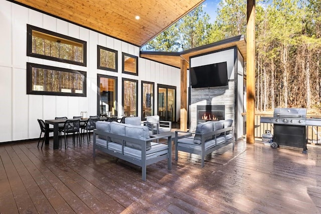 wooden deck with a grill and an outdoor living space with a fireplace