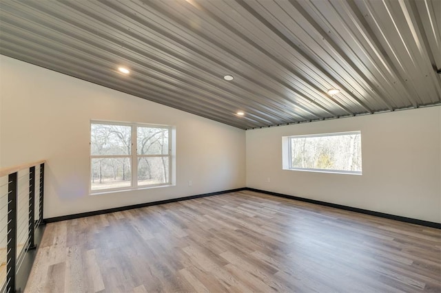 empty room featuring light hardwood / wood-style floors and vaulted ceiling