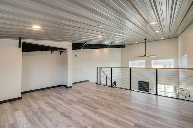 basement with ceiling fan and light hardwood / wood-style flooring