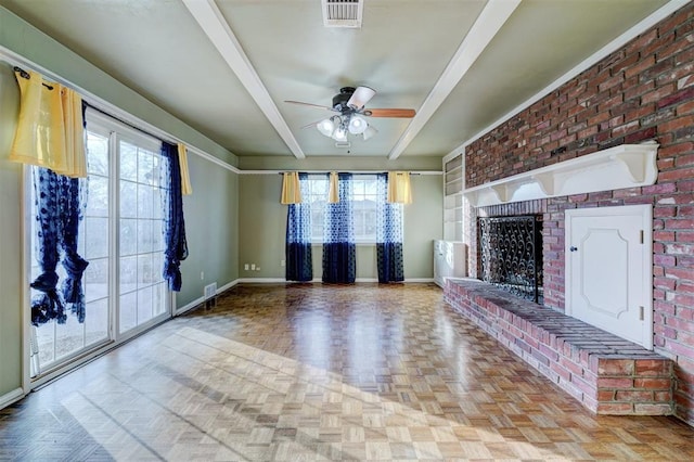 unfurnished living room with beamed ceiling, ceiling fan, a brick fireplace, and light parquet floors