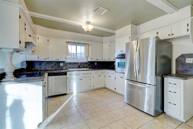 kitchen featuring sink, light tile patterned floors, appliances with stainless steel finishes, tasteful backsplash, and white cabinets