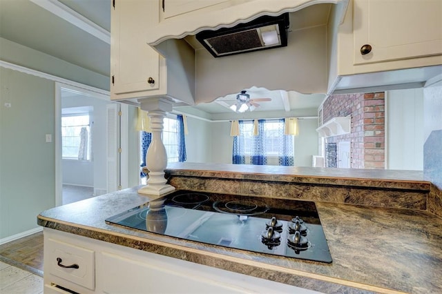 kitchen featuring black electric cooktop, ceiling fan, decorative columns, and white cabinets