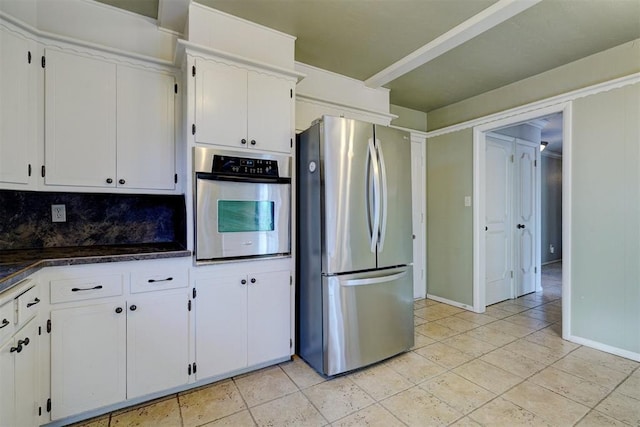 kitchen featuring white cabinetry, appliances with stainless steel finishes, light tile patterned floors, and backsplash