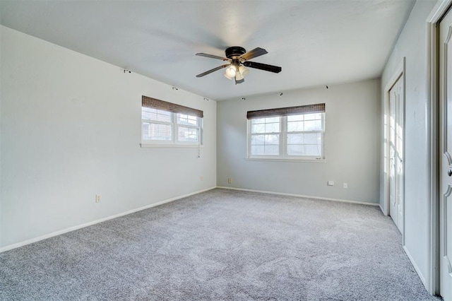 spare room with ceiling fan and light colored carpet