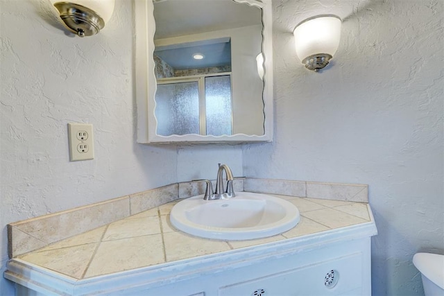 bathroom featuring vanity, an enclosed shower, and toilet