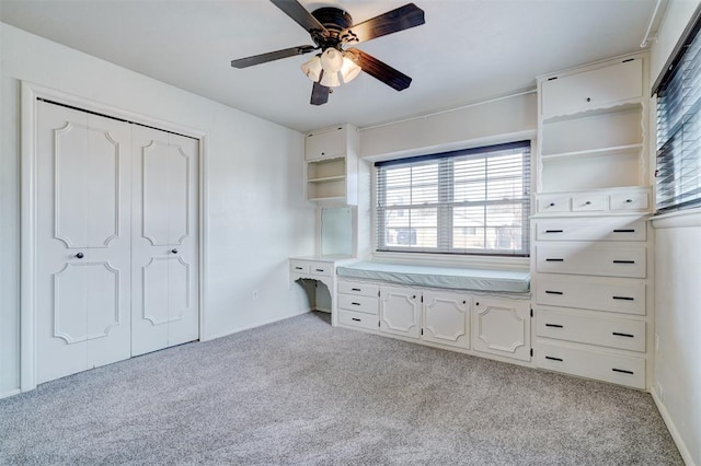 unfurnished bedroom featuring light carpet, a closet, and ceiling fan