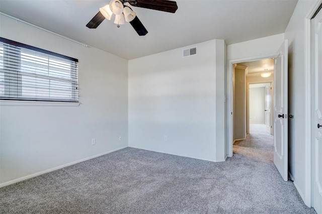 carpeted spare room featuring ceiling fan