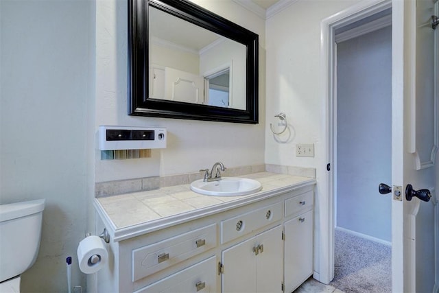 bathroom with vanity, crown molding, and toilet