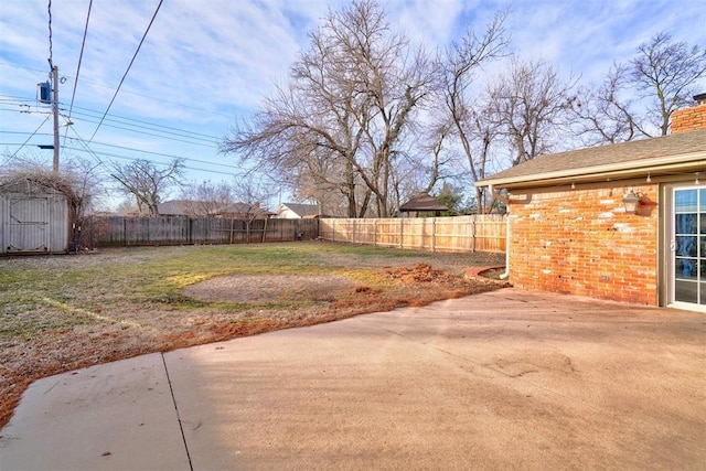 view of yard with a storage unit and a patio area