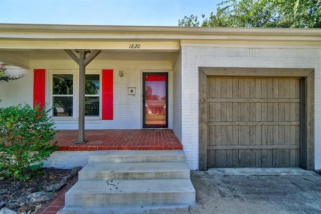 property entrance featuring a garage and covered porch