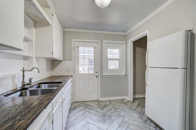 kitchen featuring sink, light parquet floors, white cabinetry, ornamental molding, and white fridge