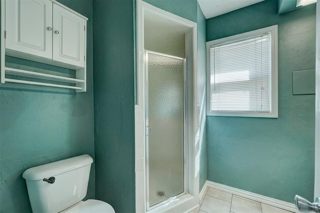 bathroom featuring tile patterned flooring, a shower with shower door, and toilet