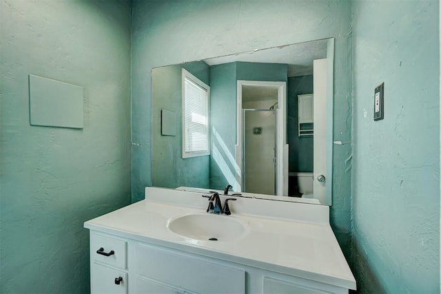 bathroom featuring an enclosed shower, vanity, and toilet