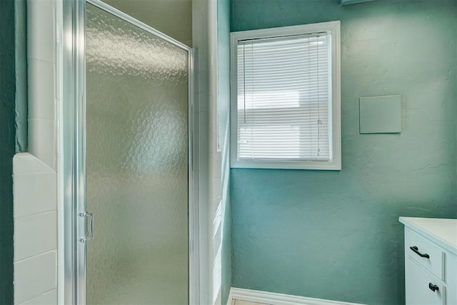 bathroom with a shower with door and vanity