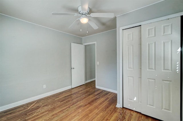 unfurnished bedroom with hardwood / wood-style floors, ceiling fan, and a closet