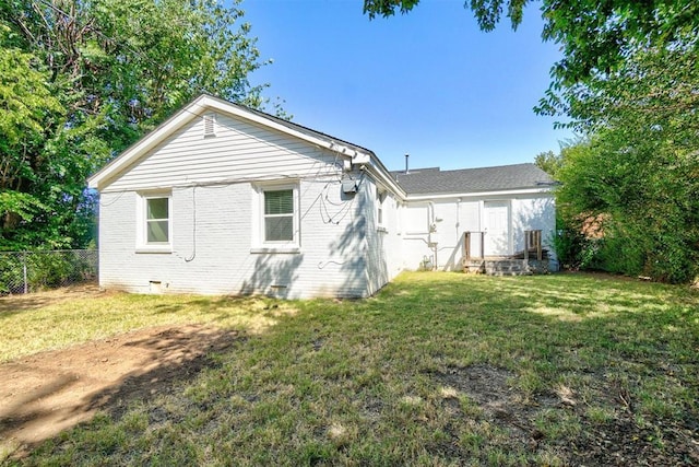 rear view of property with a lawn