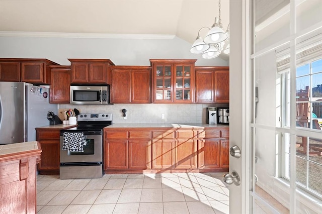 kitchen featuring lofted ceiling, decorative backsplash, stainless steel appliances, and light tile patterned flooring