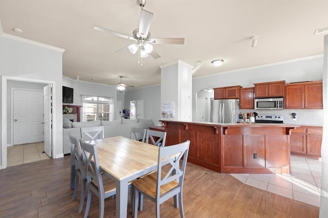 dining space featuring crown molding, hardwood / wood-style floors, and ceiling fan