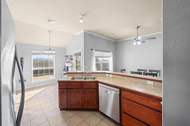 kitchen with light tile patterned flooring, appliances with stainless steel finishes, sink, hanging light fixtures, and a healthy amount of sunlight