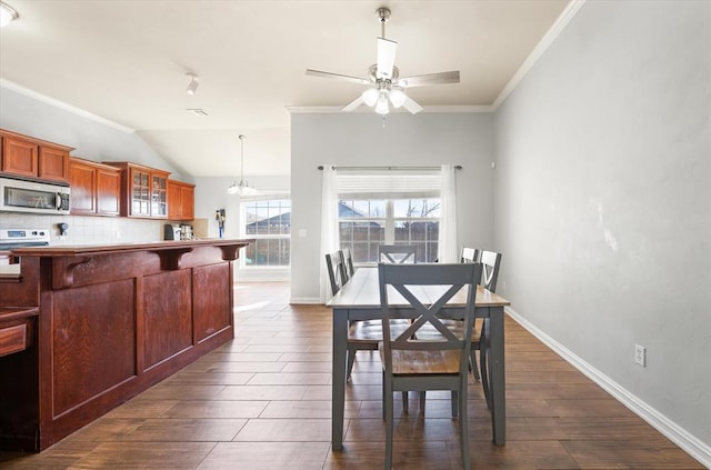 dining space featuring crown molding, dark wood-type flooring, and ceiling fan with notable chandelier