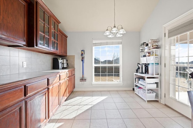 kitchen featuring pendant lighting, an inviting chandelier, tasteful backsplash, and light tile patterned floors