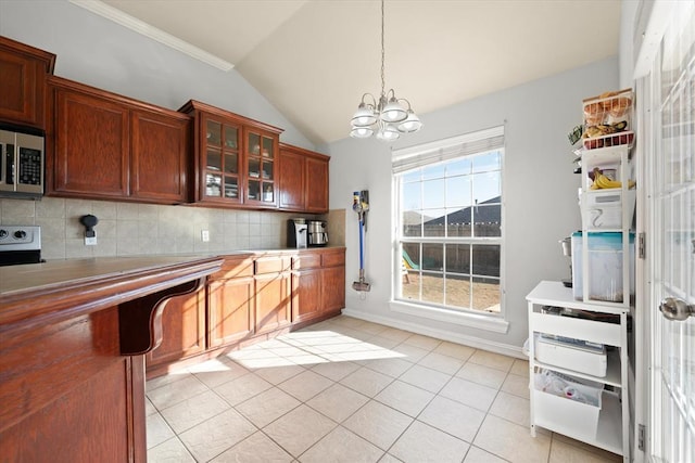 kitchen featuring lofted ceiling, decorative backsplash, hanging light fixtures, light tile patterned floors, and a notable chandelier