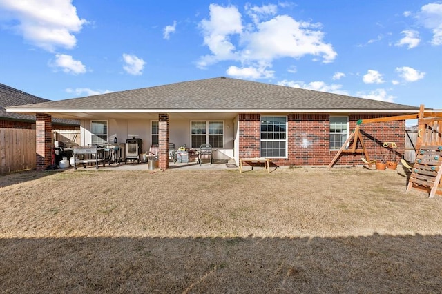 rear view of property featuring a yard, a playground, and a patio area