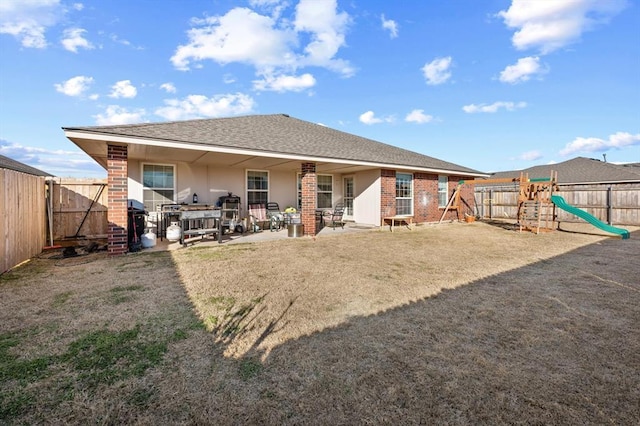 rear view of house featuring a playground and a patio area