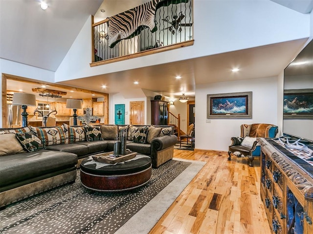 living room with high vaulted ceiling and wood-type flooring