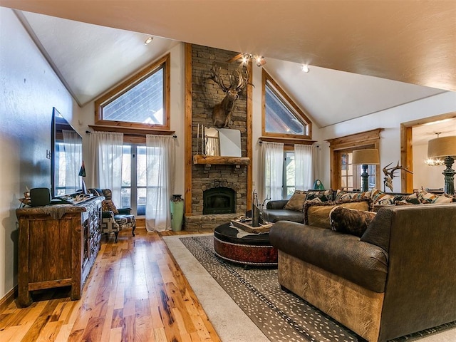 living room featuring hardwood / wood-style flooring, high vaulted ceiling, and a fireplace