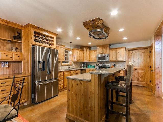 kitchen featuring a kitchen breakfast bar, sink, light stone countertops, a kitchen island, and stainless steel appliances