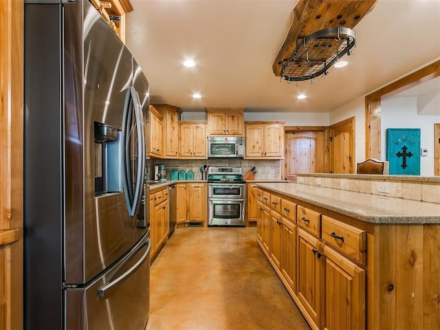 kitchen with light stone counters, appliances with stainless steel finishes, and tasteful backsplash