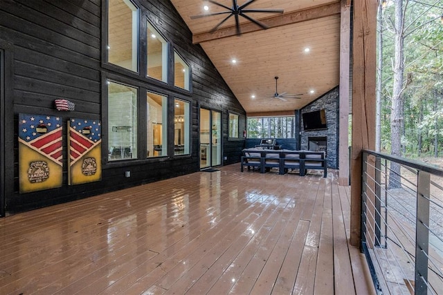 wooden terrace featuring ceiling fan and an outdoor stone fireplace