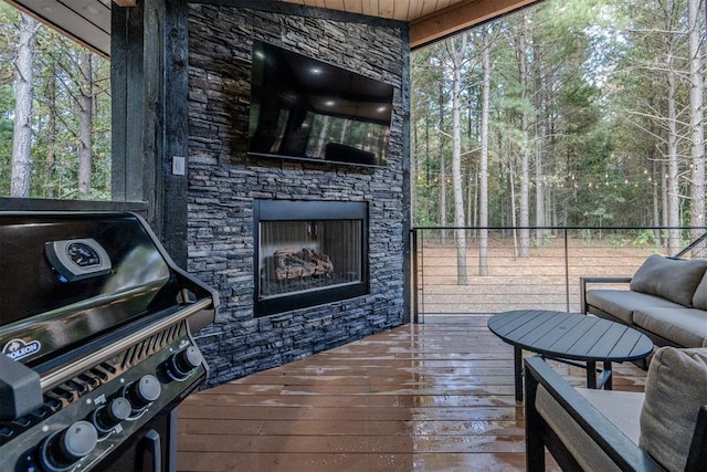 deck with grilling area and an outdoor stone fireplace