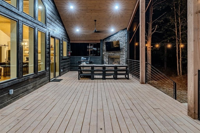 wooden terrace featuring a stone fireplace